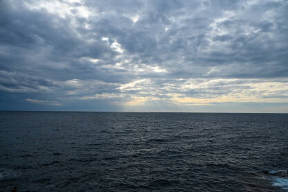 Olujno vrijeme na moru, pogled s broda. Valovi na moru sa dramatičnim oblacima iznad. Kišni zimski dan.