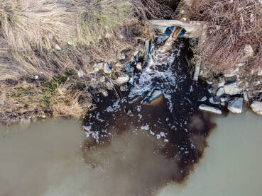 Opasne hemikalije se ispuštaju u rijeku. Industrijske otpadne vode, snimak dronom. Kanalizacija se izlijeva u rijeku. Zagađenje životne sredine. Ekološka katastrofa. Kontaminacija vode.