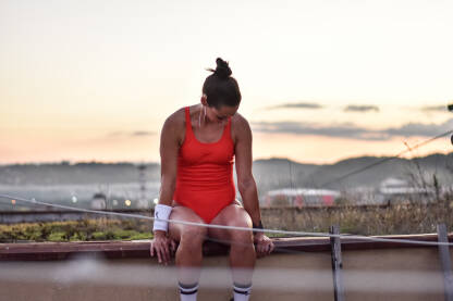 Trening na otvorenom. Djevojka odmara na krovu zgrade nakon završenog treninga.