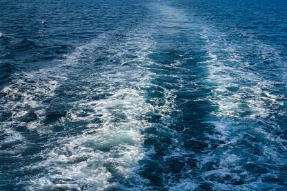 Pogled s broda na more. Brod na plavom moru lomi valove. Krstarenje trajektom.