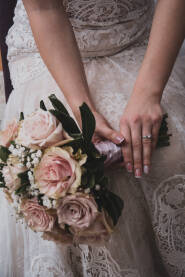 Djevojka u vjenčanici sa cvijećem u rukama.