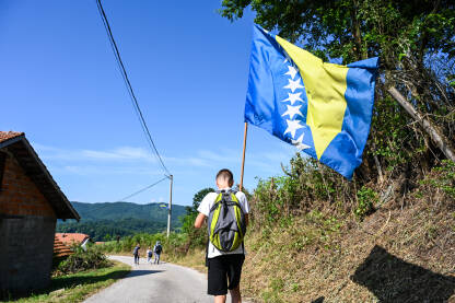 Dječak sa zastavom Bosne i Hercegovine. Mladić nosi zastavu BiH.