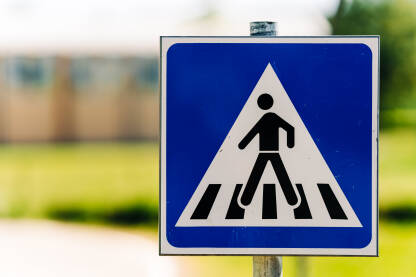 Znak "Obilježen pješački prelaz" označava mjesto na putu gdje se nalazi obilježen pješački prelaz. Krupni plan.