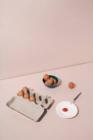 Svježa jaja u kartonskoj kutiji i keramičkoj posudi pripremljena za farbanje. Pozadina ili čestitka za Uskrs / Vaskrs.