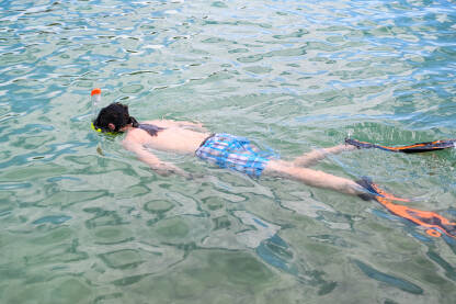 Dječak roni u moru sa maskom i dihalicom. Ljetni godišnji odmori.