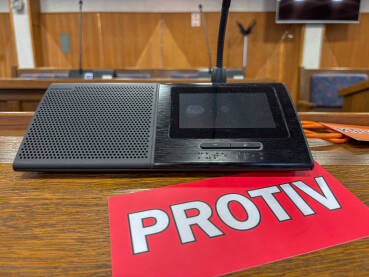 Sjednica u skupštini. Natpis PROTIV pored poslaničkog mikrofona.