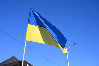 Ukrajinska zastava vijori se na vjetru. Zastava Ukrajine na jarbolu. Plava i žuta boja na ukrajinskoj zastavi.
