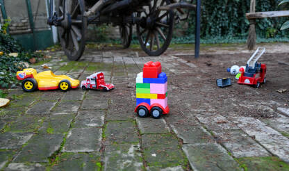 Dječje igračke u dvorištu. Autići i slagalice.