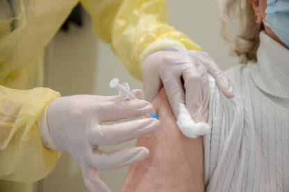 Medicinska sestra daje vakcinu starijoj ženskoj osobi. Cijepljenje stanovništva. Cijepljenje protiv virusa COVID-19 tokom pandemije koronavirusa. Vakcina.