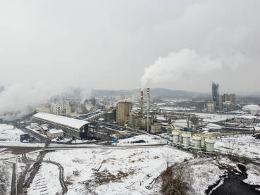 Zagađenje zraka iz tvornice. Industrijski kompleks, snimak dronom. Tvornički dimnjak zagađuje okoliš. Industrijsko onečišćenje zraka. Dim iz dimnjaka u industrijskoj zoni tokom zime.