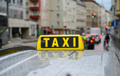 Taxi znak na krovu automobila. Taksi na ulici. Taxi stajalište u gradu. Prijevoz.