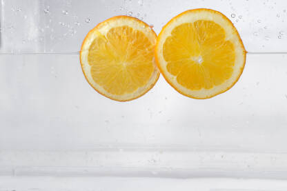 Kriške limuna prskaju vodom, izolirane na bijeloj pozadini