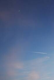 Nebo plave boje sa polumesecom u daljini i linijom putanje aviona