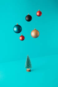 Božićno, novogodišnje drvce i ukrasne kuglice u zraku. Blagdanska čestitka.
