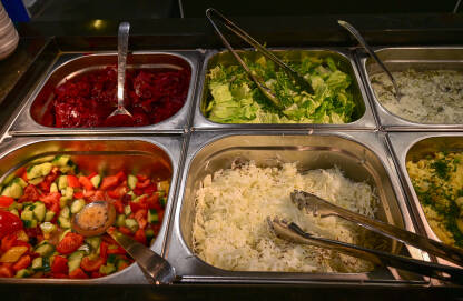 Svježe salate u restoranu. Zelena salata, kupus, krastavac, paradajz, paprika, krompir.