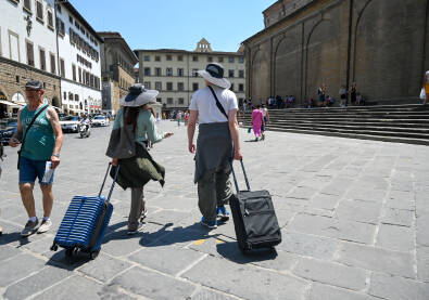 Turisti sa koferima u gradu. Ljudi putuju. Firenza, Italija, grupa ljudi na trgu.