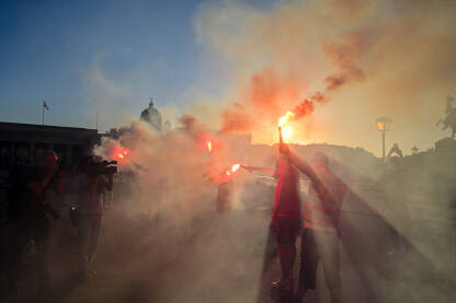 Grupa ljudi drži baklje na protestu. Demonstranti s dimom i bakljama tokom demonstracija. Javne demonstracije. Ljudi protestuju s ručnim bakljama.