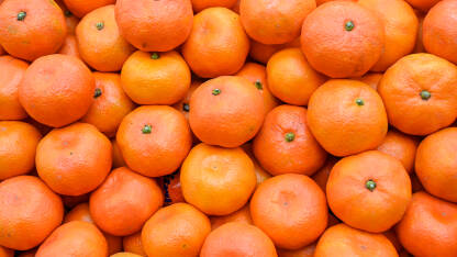 Svježe mandarine na pijaci. Kutije pune zrelih mandarina u supermarketu. Voće. Sočna mandarina na štandu u trgovini.
