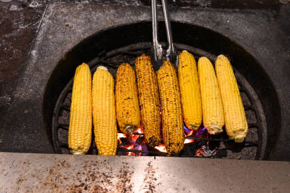 Kukuruz se peče na roštilju. Grilovani kukuruz u klipu na vrućoj vatri. Kukuruz za prodaju u gradu.
