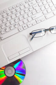 Povešina radnog stola, sa laptopom i naočalama.