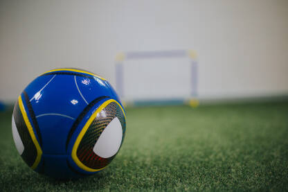 Plava fubalska lopta za golom u pozadini