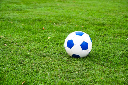 Lopta za fudbal na zelenoj travi na stadionu. Igranje nogometne utakmice. Klasična fudbalska lopta.