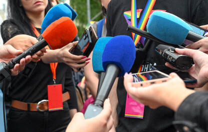 Mnogo mikrofona na konferenciji na press konferenciji. Snimanje zvuka. Novinarstvo. Novinari i novinarke drže profesionalne mikrofone i snimače zvuka.