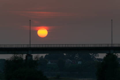 Silueta mosta na rijeci Savi u Brodu i veliko sunce u veče