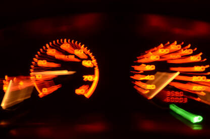 Brzinomjer u automobilu tokom vožnje. Brzina. Ubrzanje automobila i osvjetljeni brzinomjera noću. Osvjetljena instrument tabla u vozilu.