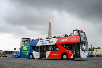 Pariz, Francuska: Dvospratni turistički autobus na ulici. Turistički autobus. Obelisk na Place de la Concorde. Ljudi na trgu u Parizu.