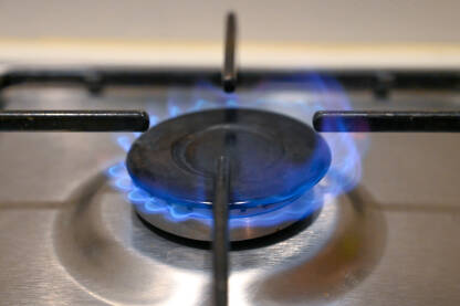 Plinski šporet u kuhinji. Plavi plamen na plinskom štednjaku u kući. Krupni plan vatre na plinskom štednjaku.