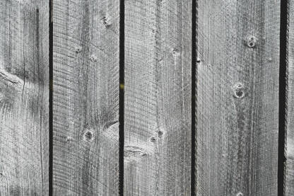 Drvena tekstura. Stara drvena ograda u blizini kuće. stare i suve daske. Siva drvena podloga.