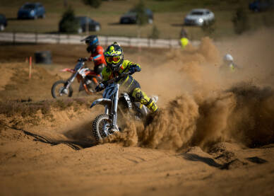 Vozač cross motora tokom trke. Motocross trka. Takmičenje u vožnji cross motora.