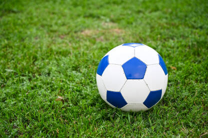 Lopta za fudbal na zelenoj travi na stadionu. Igranje fudbalske utakmice.