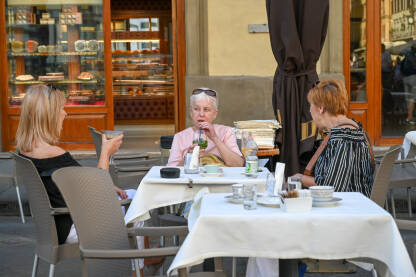 Turisti piju piće na terasi restorana. Ljudi sjede u kafiću.