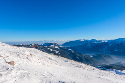 Planinar na snijegu prilikom zimskog uspona na planini Hajla u Crnoj Gori i Kosovu. U pozadini magla i vrhovi Šar planine u Sj.Makedoniji.