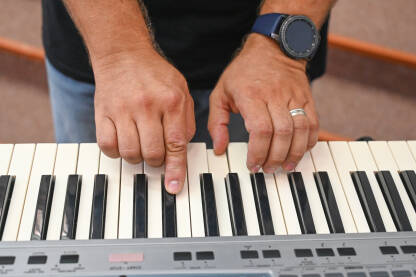 Muškarac svira piano. Muzičar svira električni piano. Muzički instrument.