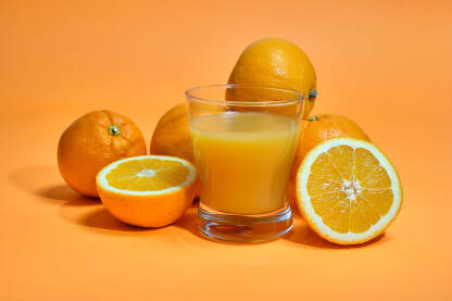 Narandže i čaša cijeđenog soka