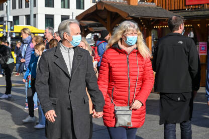 Stariji ljudi s maskom za lice hodaju ulicom. Covid-19 zaštita. Starije osobe s medicinskom maskom šetaju gradom. Zaštita od korona virusa.