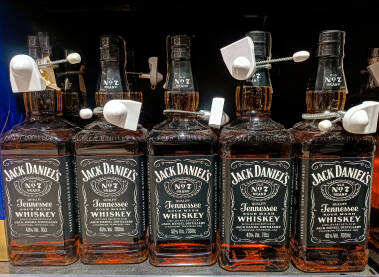 Boce viskija Jack Daniel's Old No. 7 Tennessee izložene na polici sa sigurnosnim sistemom protiv krađe. Izbor alkoholnih pića u maloprodaji.