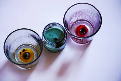 Tri dogorjele mirisne svijeće u staklenim posudama.