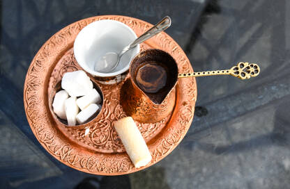 Bosanska, domaća ili turska kafa servirana na stolu u restoranu. Kafa u džezvi sa fildžanima, šećerom i lokumom. Ukrašena bakrena tacna.