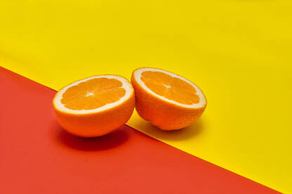 Dvije kriške narandže na crveno-žutoj pozadini