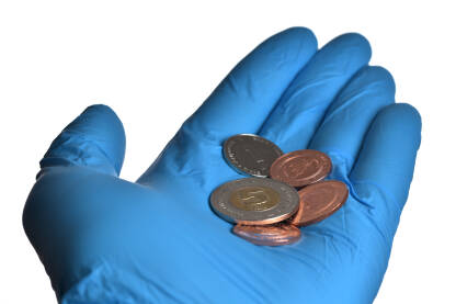 Kovanice konvertibilne marke na dlanu u plavoj zaštitnoj rukavici. Izolovano na bijeloj pozadini