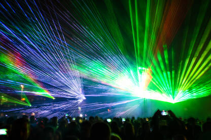 Laserska svjetla i dim na bini tokom koncerta. Višebojni svjetlosni efekti. Apstraktna pozadina. Laserski snop. Laser show.