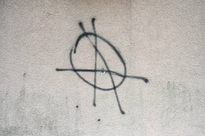 Znak anarhije nacrtan na zidu. Grafit u gradu. Simbol anarhije.