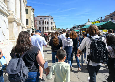 Gužva na ulici. Ljudi sa torbama šetaju gradom. Turisti istražuju grad.