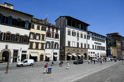 Firenca, Italija: Ljudi šetaju trgom. Zgrade u centru grada. Turisti istražuju grad.