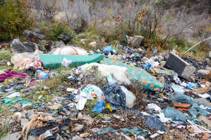 Divlja deponija smeća u prirodi. Otvorena deponija. Gomila smeća. Ilegalno odlaganje otpada. Zagađenje životne sredine. Iznutrice životinja, plastične flaše, stari nameštaj, auto gume, ambalaža...
