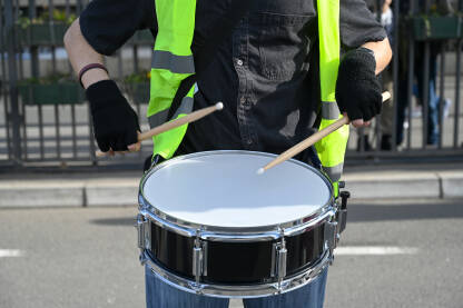 Djevojka svira doboš (bubnjeve). Djevojka svira doboš. Muzičarka svira bubnjeve. Žena svira doboš tokom protesta.